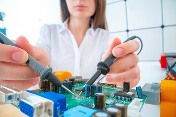 Wall Mural - Young woman with measuring devices in the electronics engineer  laboratory