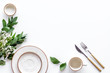 White plates and flowers for table setting frame on white background top view mockup