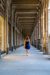 Wall Mural - Blue dress girl in covered passage in the royal palace of Paris