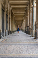 Wall Mural - Blue dress girl in covered passage in the royal palace of Paris