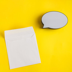 Bubble text speech empty and paper card on sunny yellow background. Place for text, lettering or product. View from above, Copy space. Flatlay.