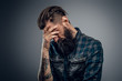 © Fxquadro - Bearded skinny man with tattooes feels dispair and sorrow while thinking about life.