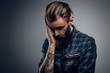 © Fxquadro - Bearded skinny man with tattooes feels dispair and sorrow while thinking about life.
