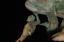 Male Mermaid Sculpture Of A Fountain At Night