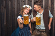 © karepa - Junge Frau und mann mit Bierkrug und Brezel auf einem Holzhintergrund .Oktoberfest-Konzept