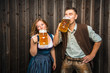 © karepa - Junge Frau und mann mit Bierkrug und Brezel auf einem Holzhintergrund .Oktoberfest-Konzept