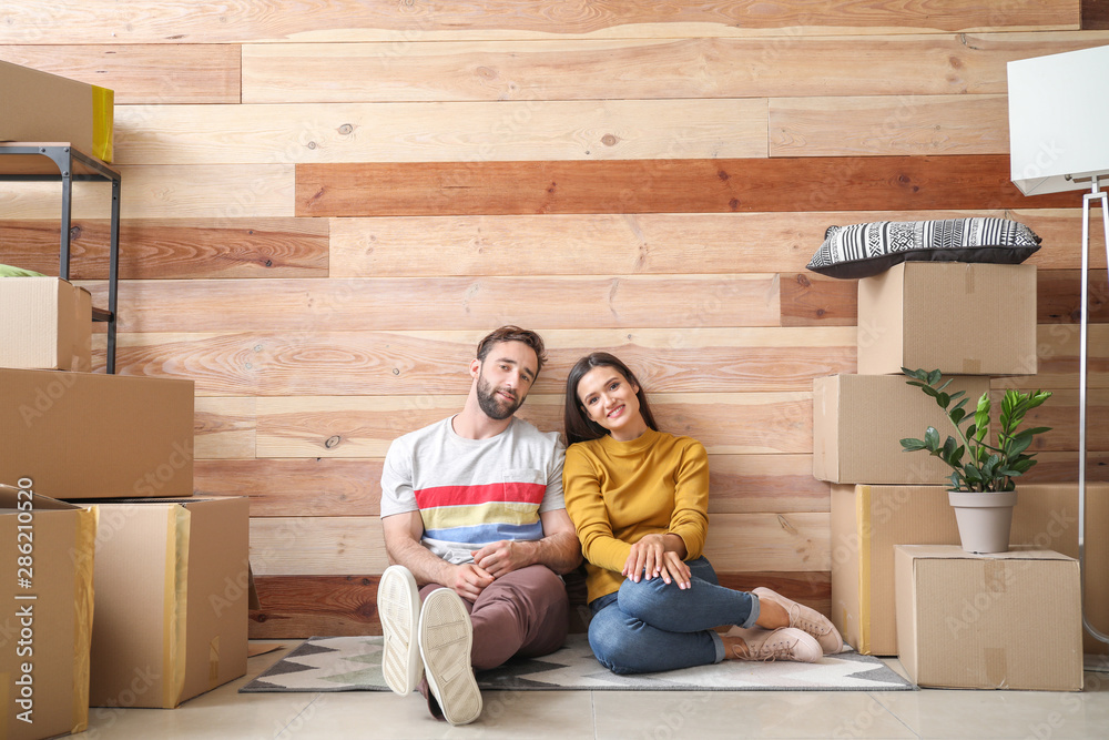 Young couple with belongings after moving into new house