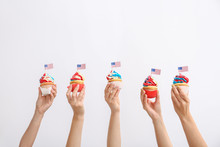 Female Hands With Tasty Patriotic Cupcakes On White Background
