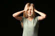 © Pixel-Shot - Stressed young woman on dark background