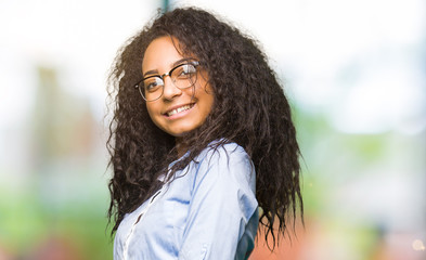 Canvas Print - Young beautiful business girl with curly hair wearing glasses Inviting to enter smiling natural with open hand