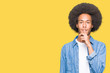 Young african american man with afro hair asking to be quiet with finger on lips. Silence and secret concept.