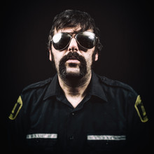 Male Cop With A Large Mustache, Shaggy Hair And Sunglasses.