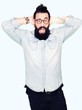 © Krakenimages.com - Young hipster man with long hair and beard wearing glasses Crazy and scared with hands on head, afraid and surprised of shock with open mouth