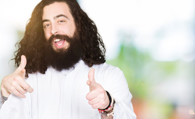 Man wearing Jesus Christ costume pointing fingers to camera with happy and funny face. Good energy and vibes.