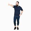 © Krakenimages.com - Young hipster man with long hair and beard wearing glasses Pointing with finger surprised ahead, open mouth amazed expression, something in front