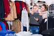 © JackF - Smiling preteen girl with young mother shopping for clothes in shop