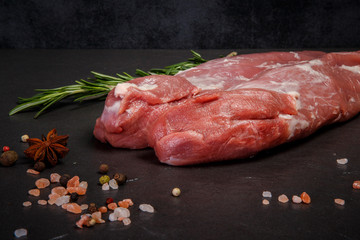 closeup two long pieces of raw marbled meat with rosemary