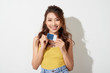 © makistock - Portrait of an excited happy asian woman holding credit card isolated over white background