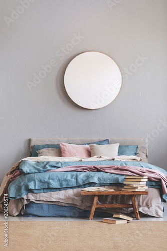 Round Mirror In Wooden Frame On Grey Wall Of Elegant Bedroom