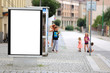 Bilbord reklamowy w centrum miasta, w tle dzieci na chodniku, przystanku autobusowym. 