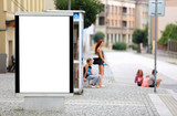 Fototapeta Miasto - Bilbord reklamowy w centrum miasta, w tle dzieci na chodniku, przystanku autobusowym. 