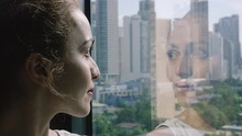 Beautiful Woman Is Looking At The City With The Reflection Of Her Face In The Window. She Can See The City And Buildings Of Manila, Philippines - Lifestyle Travel Concept