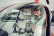 © Viacheslav Yakobchuk - Bearded pilot using his tablet while sitting in little helicopter