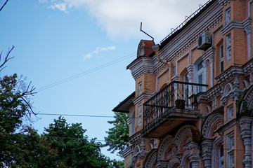 Angle of antique building with balcony. Architecture large building of antique roman style with pillars and blue sky