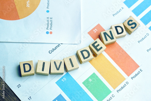 Fotografía Text DIVIDENDS on wood dice which lay on graph volume document for up trend in stock investment concept