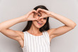 © Drobot Dean - Image of caucasian brunette woman wearing dress smiling and showing heart shape with fingers