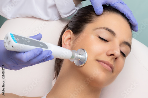 Fotomural Woman having non surgical face lift with laser plasma pen.