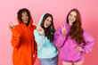 © Drobot Dean - Pleased smiling young three multiethnic girls friends posing isolated over pink wall background showing peace gesture.