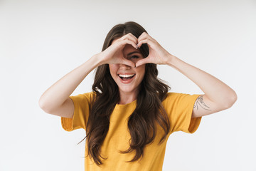 Poster - Image of beautiful brunette woman wearing casual clothes smiling and showing heart shape with fingers