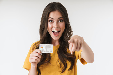 image of pleased brunette woman wearing casual clothes pointing finger at camera and holding credit 