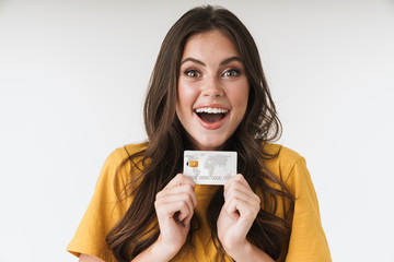 Wall Mural - Image of astonished brunette woman wearing casual clothes smiling and holding credit card