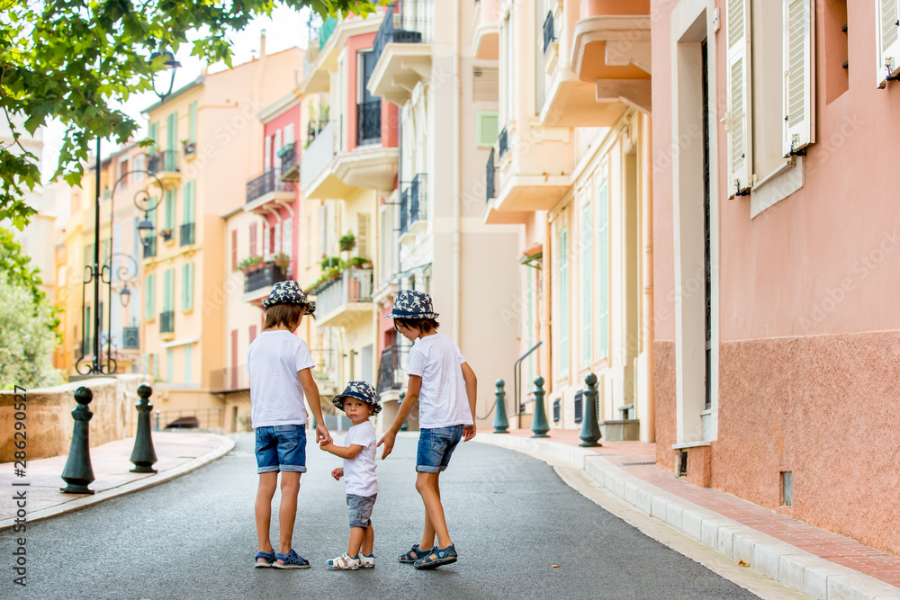 Obraz na płótnie Children walking on a narrow street with houses in Monaco-Ville, Monaco on a cloudy day w salonie