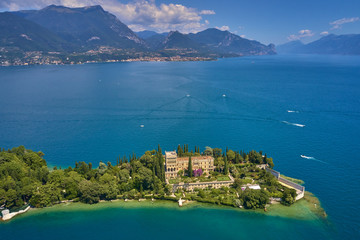 Wall Mural - Unique view of the island of Garda. In the background is the Alps. Resort place on Lake Garda north of Italy. Aerial photography.