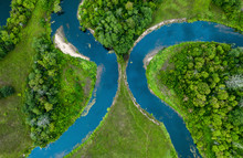 Top View Drone Shot Of A Green Field, Forest And River
