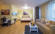 © Aleks Kend - Modern interior of light studio apartment. King-size bed. Served table. Cozy sofa.