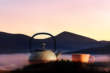 An Original Cast-iron Kettle And A Cup Overlooking The Mountain Landscape.