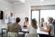 © NDABCREATIVITY - Team of colleagues brainstorming together while working in modern office