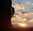 © anatoliy_gleb - Side view of strong rock climber at dawn. Male silhouette on high rocky wall having extreme outdoors activity. Concept of perseverance and never give up. Sunrise sky with clouds and copy space