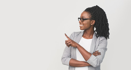 Smiling Black Businesswoman Pointing Finger At Copy Space, White Background