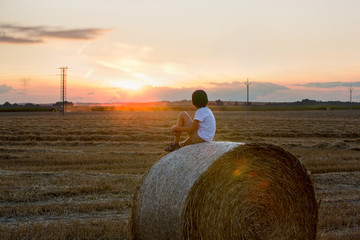 Happy children, playing on haystacks summertime