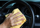 Fototapeta Przestrzenne - Closeup of inner side car cleaning by woman's hand with yellow microfiber cloth.