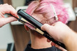 © okskukuruza - hairdresser straightening pink hair with hair irons