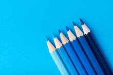 Macro Photograph Of Several Pencils Of Blue Color On A Paper Background