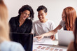 © Monkey Business - Team Of Young Businesswomen In Meeting Around Table In Modern Workspace