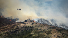 Firefighting Helicopter With Bucket Drop Water On Forest Fire Or Wildfire.