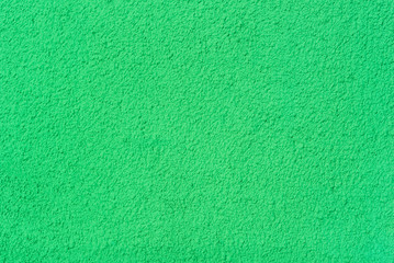 Wall Mural -  Photo of a wall with a rough texture of plaster painted in green